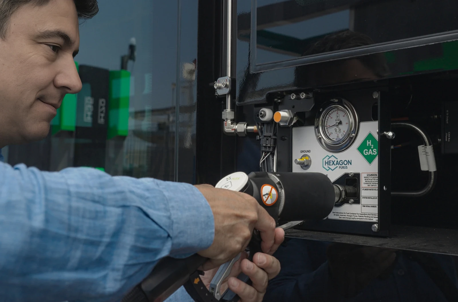 Man refuelling CaetanoBus with hydrogen nozzle