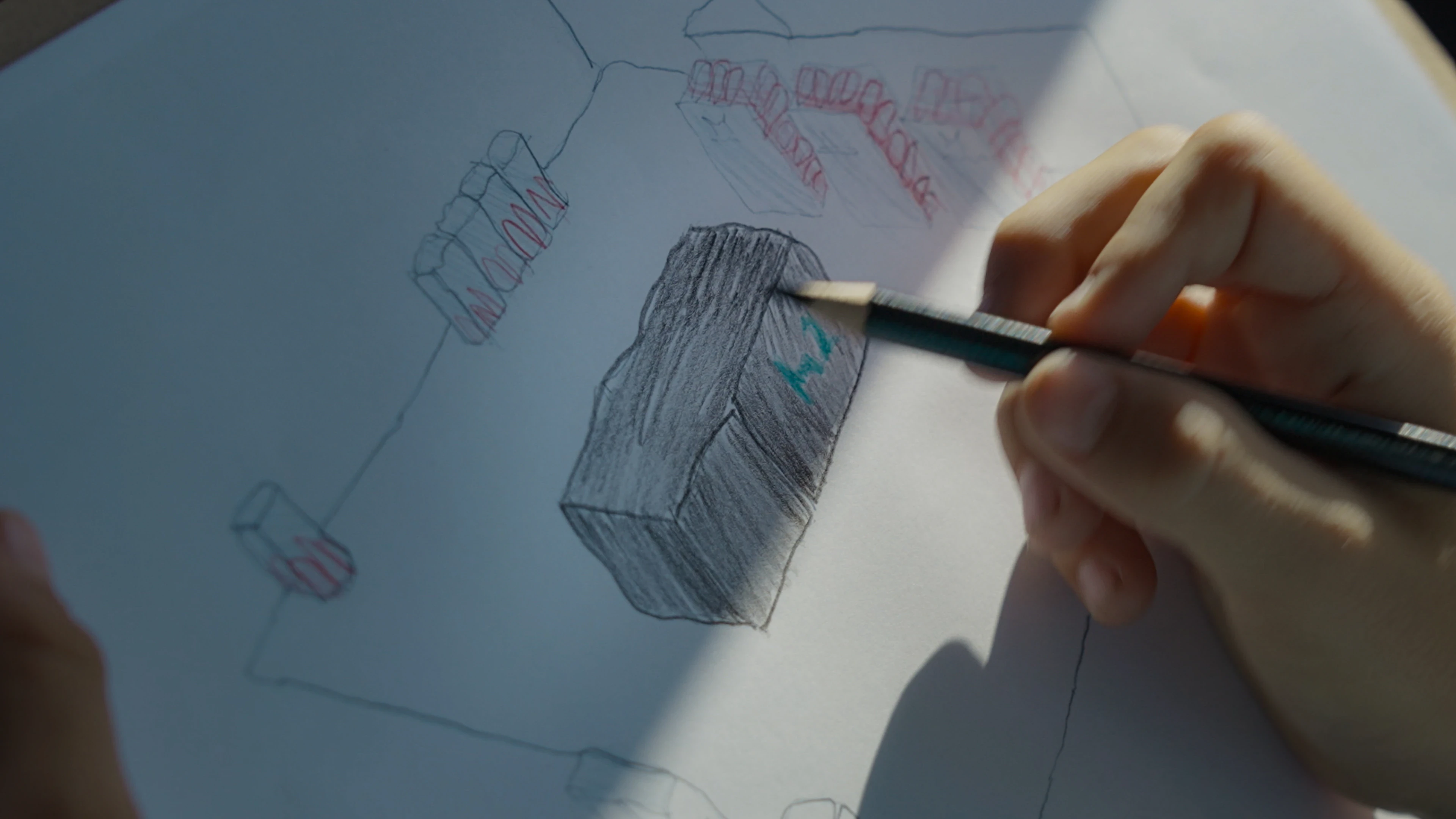 Close-up of child's hand drawing the H2 station on paper