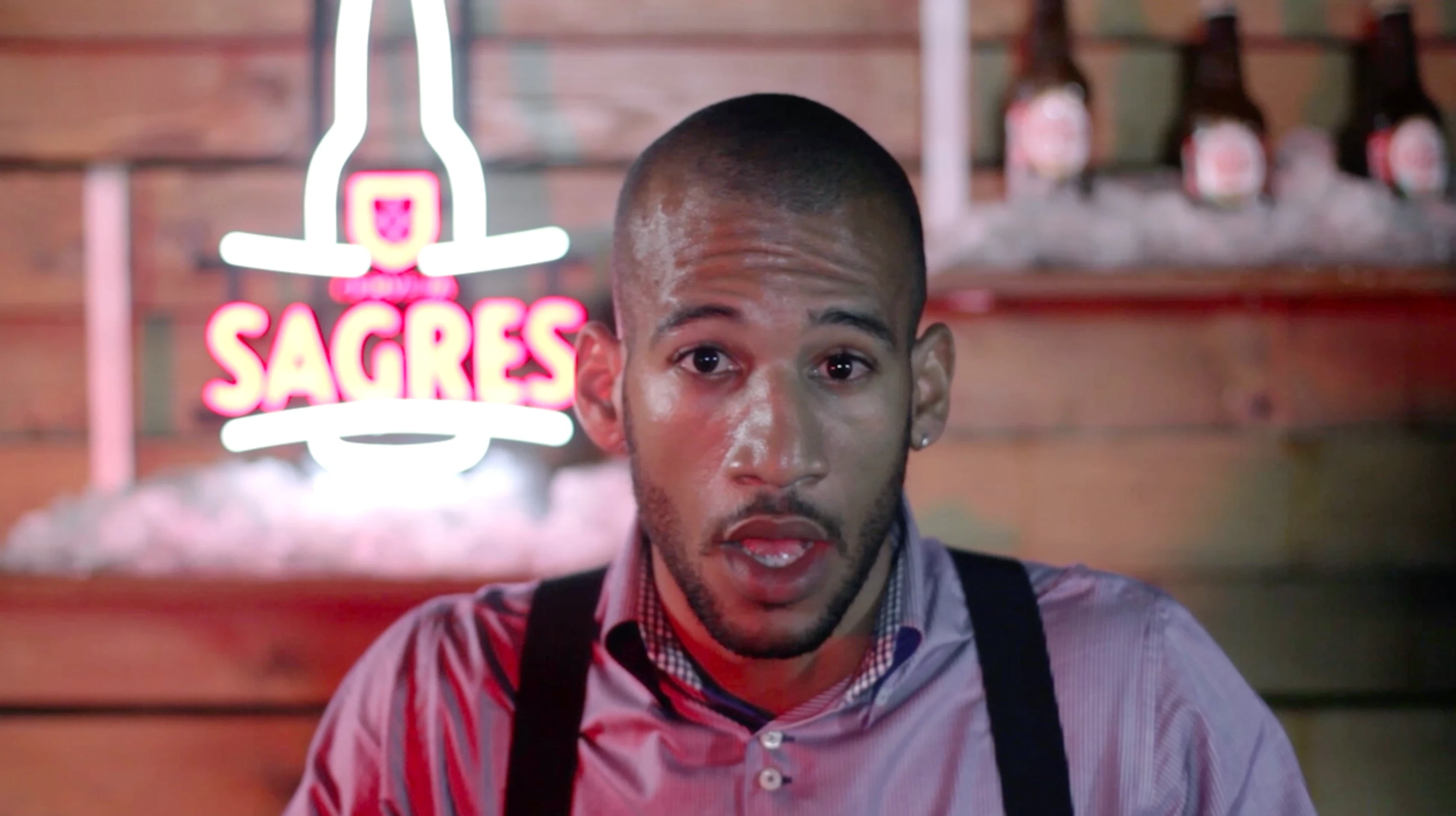 TV spot still: bartender in front of Sagres neon sign