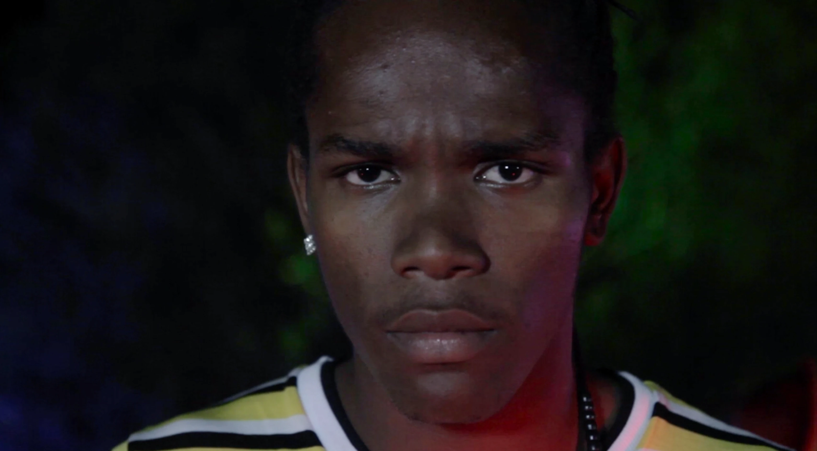 TV spot still: close-up young man, dramatic lighting